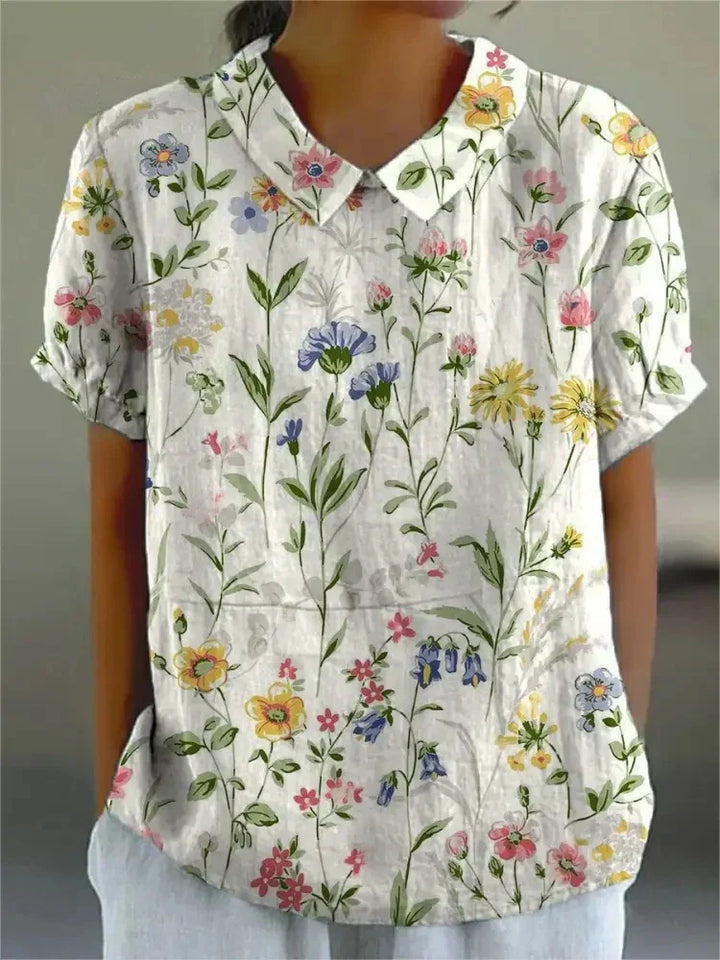 Women's elegant floral blouse with short sleeves and Peter Pan collar, featuring a vibrant floral pattern for stylish summer 