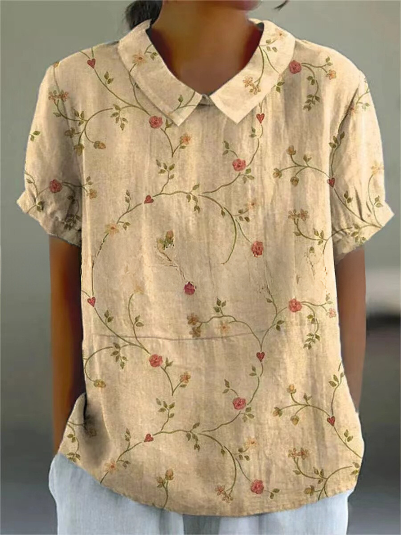 Women's elegant floral blouse with short sleeves and Peter Pan collar, featuring a vibrant floral pattern for stylish summer 