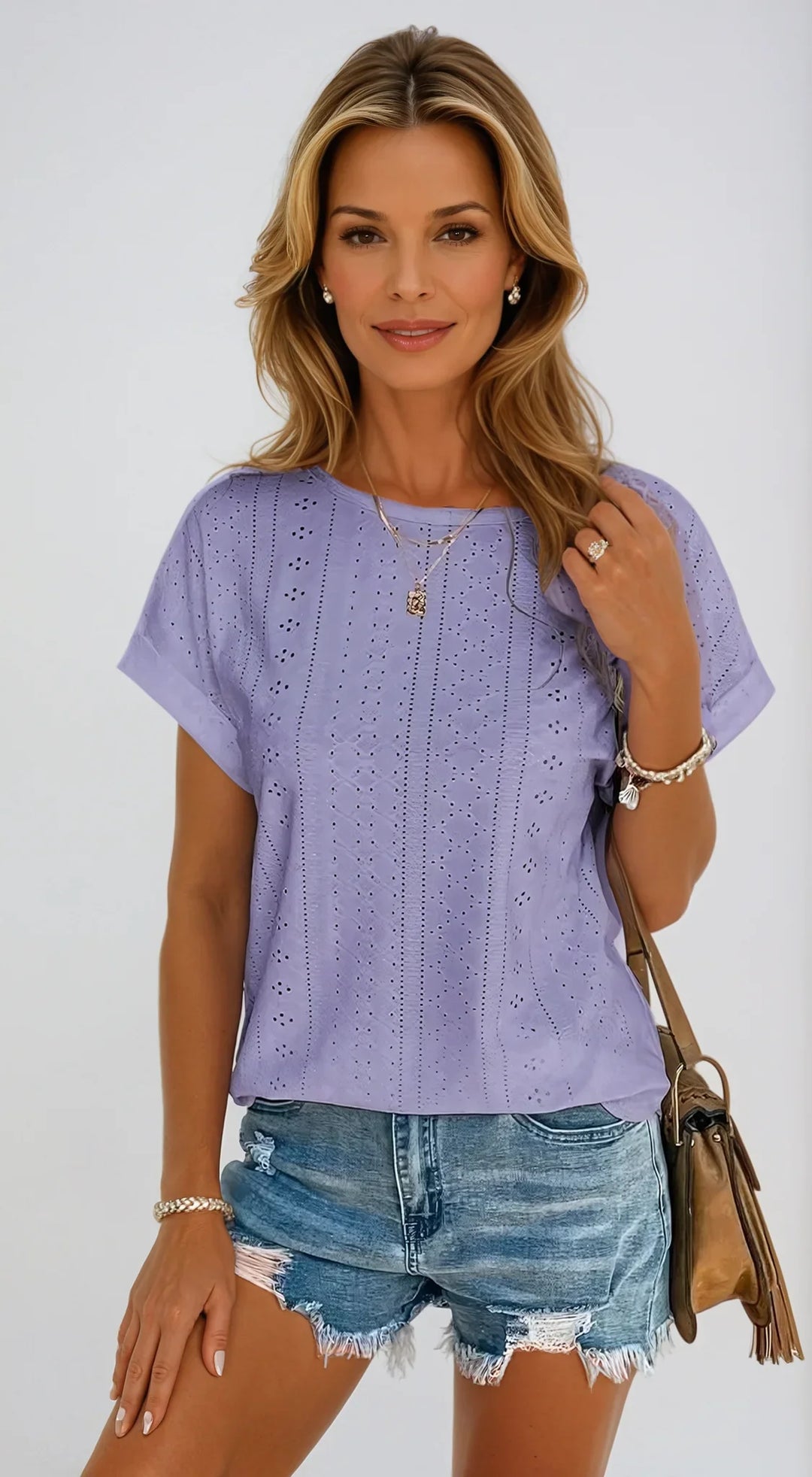Fashionable women's eyelet short sleeve top. Crew neck and cuffed sleeves for a chic spring look.