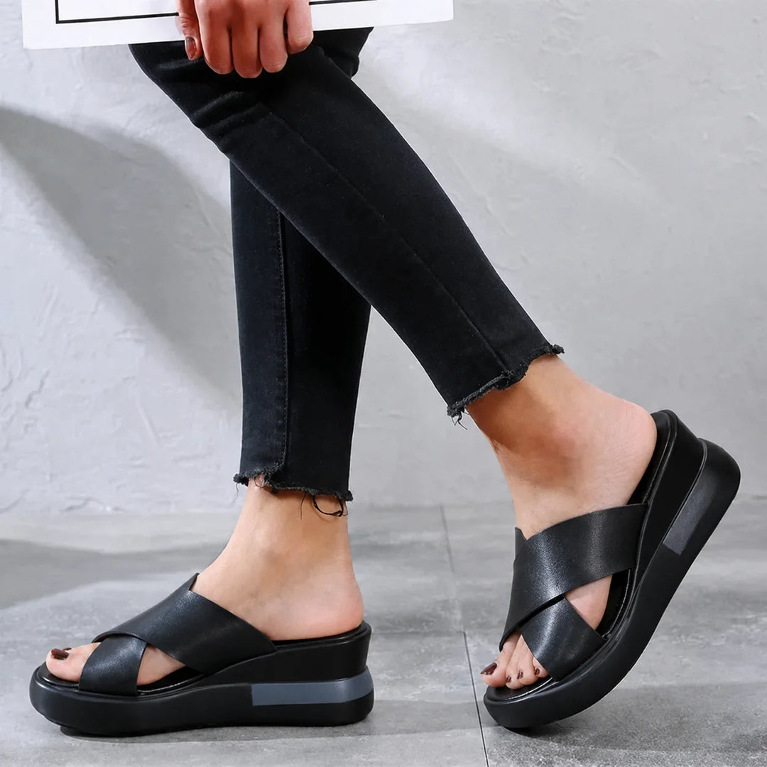Easy slip-on women's flat sandals with elegant cross-straps, providing comfort for all-day summer wear.