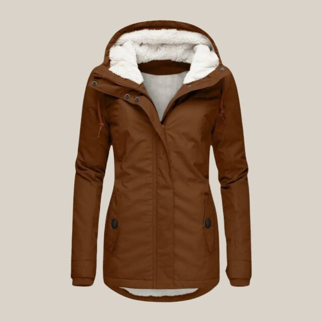 Woman in a chic hooded quilted winter jacket, fleece-lined for warmth during outdoor activities.