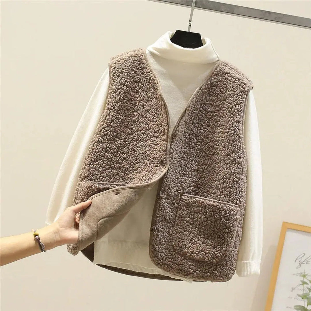 Warm women's button-up puffer vest. Reversible design with soft sherpa, great for cold weather layering.