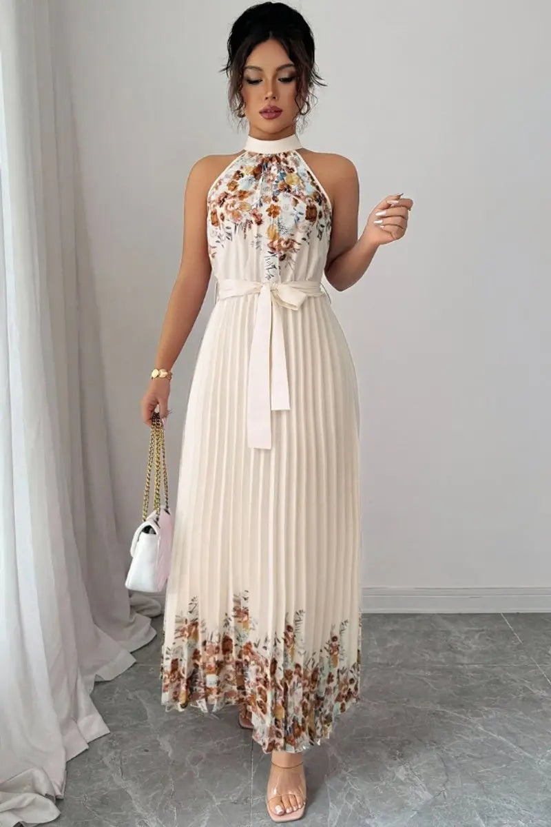 Women's pleated floral halter neck maxi dress, showcasing a delicate neckline & flowing skirt.