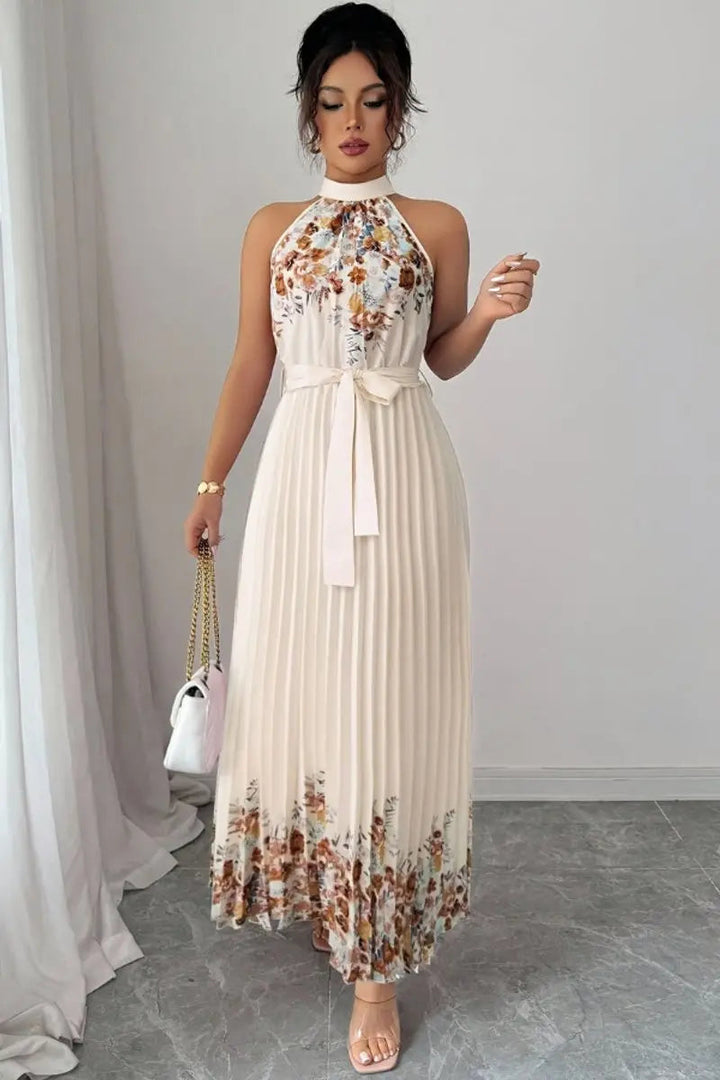 Women's pleated floral halter neck maxi dress, showcasing a delicate neckline & flowing skirt.