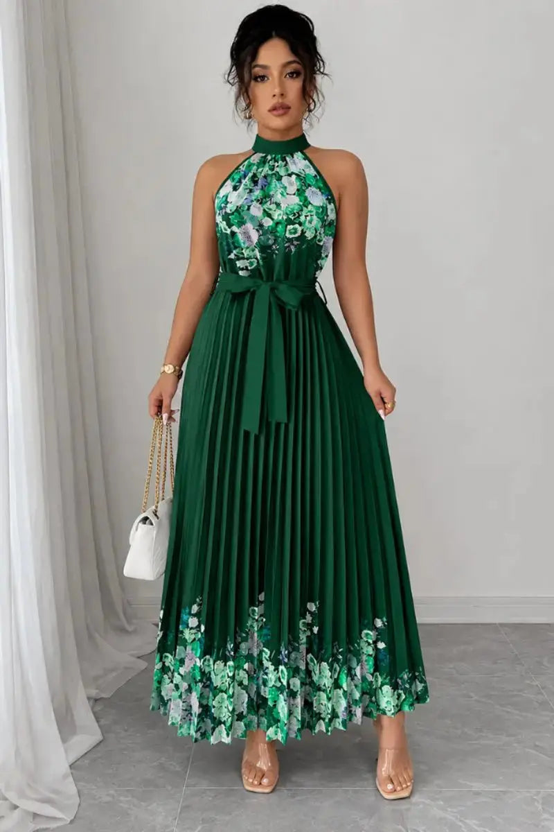 Close-up of elegant floral print on women's pleated halter neck maxi evening gown.