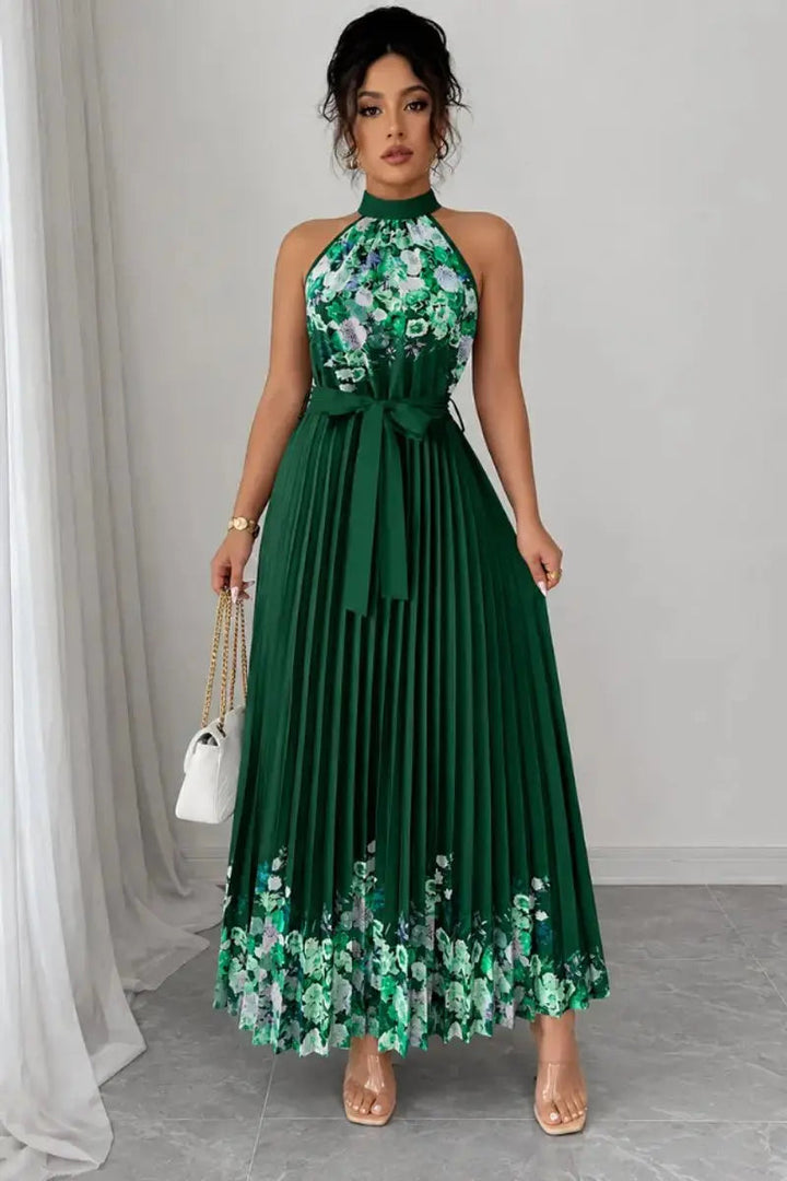Close-up of elegant floral print on women's pleated halter neck maxi evening gown.