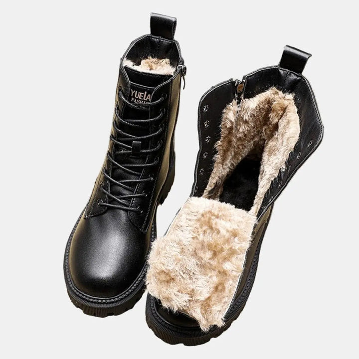 Black fur-lined women's combat ankle boots with lace-up design and chunky sole, perfect for warm winter style.