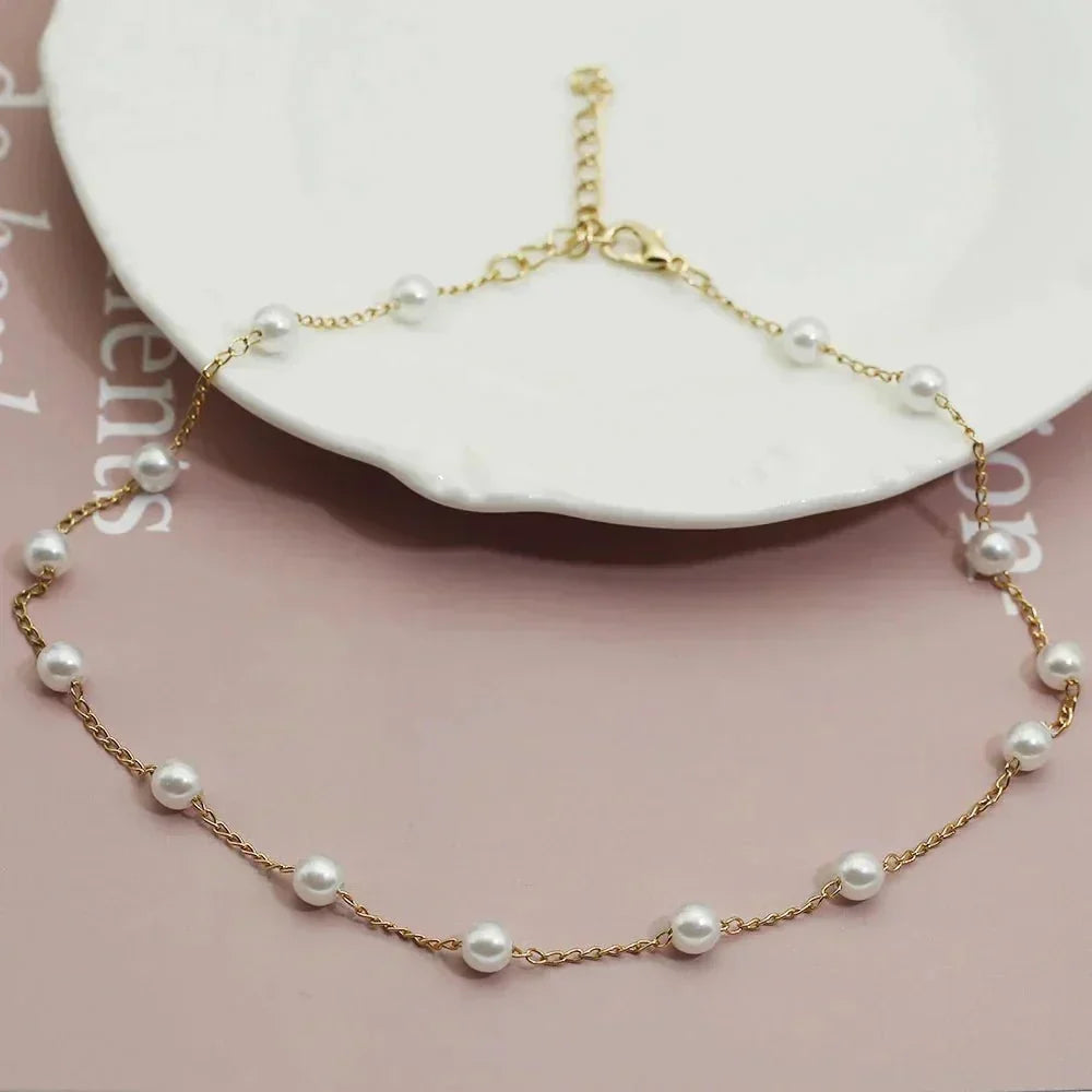Women's elegant gold pearl choker necklace. A delicate, fashionable jewelry piece with a shiny pearl.