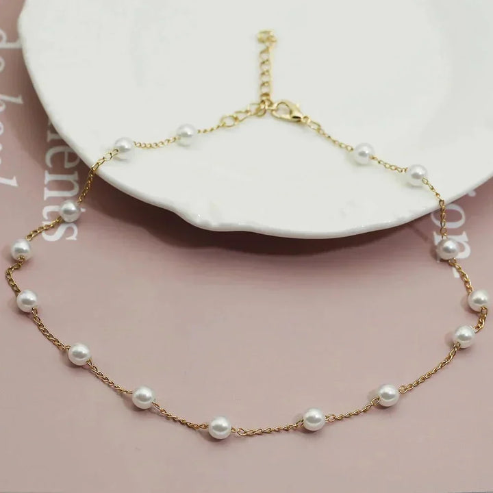Women's elegant gold pearl choker necklace. A delicate, fashionable jewelry piece with a shiny pearl.