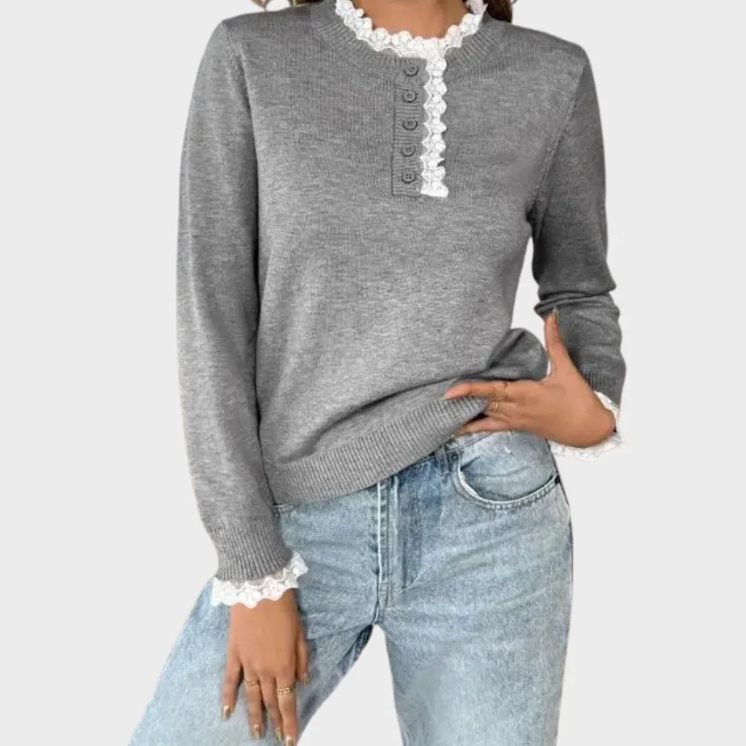 Close-up of the delicate lace-trim mock-neck on a grey women's retro long-sleeve sweater. Vintage style elegance.