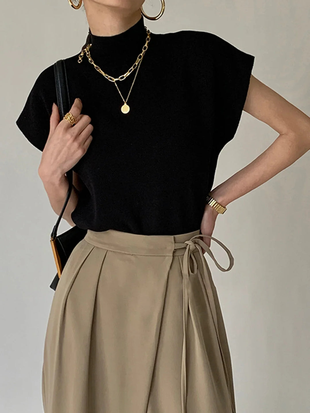 Women's elegant mock neck knit top with padded cap sleeves for a sophisticated, structured look.