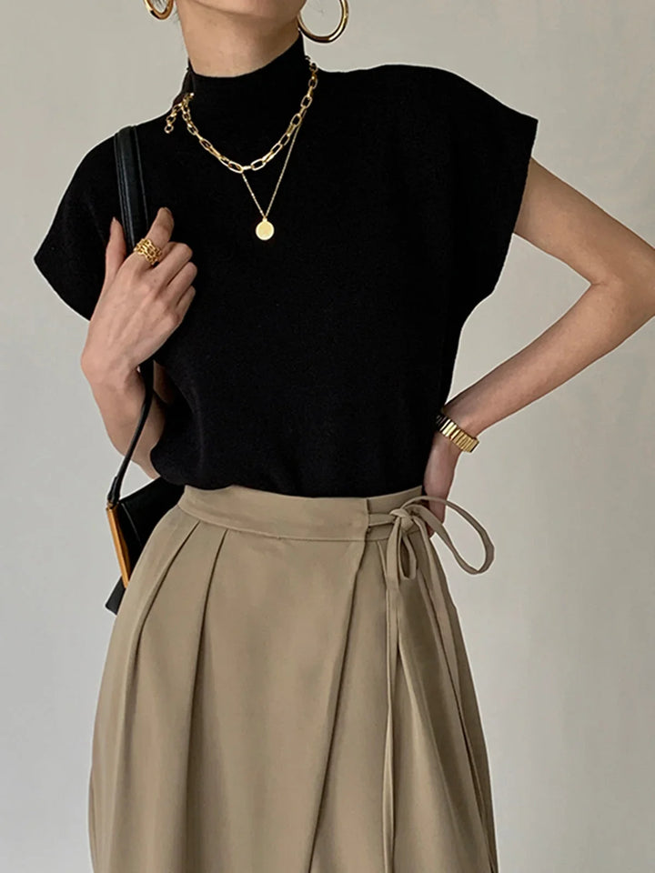 Women's elegant mock neck knit top with padded cap sleeves for a sophisticated, structured look.