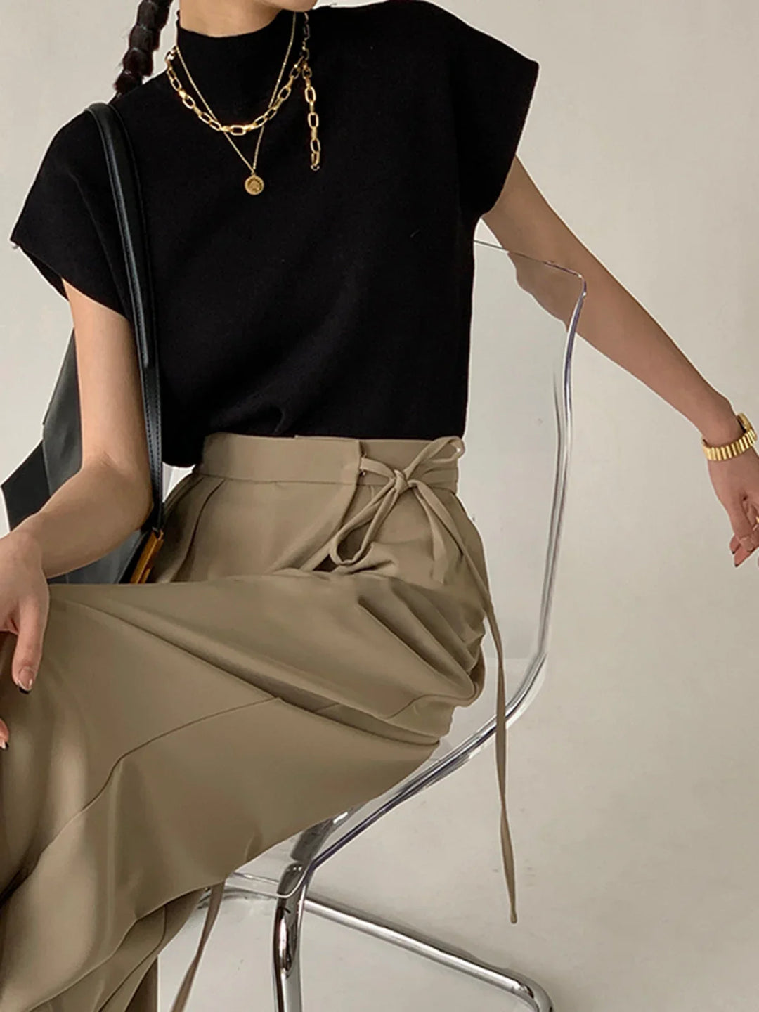 Fashion-forward women's knit top: mock neck, padded shoulders, cap sleeves, structured elegance.