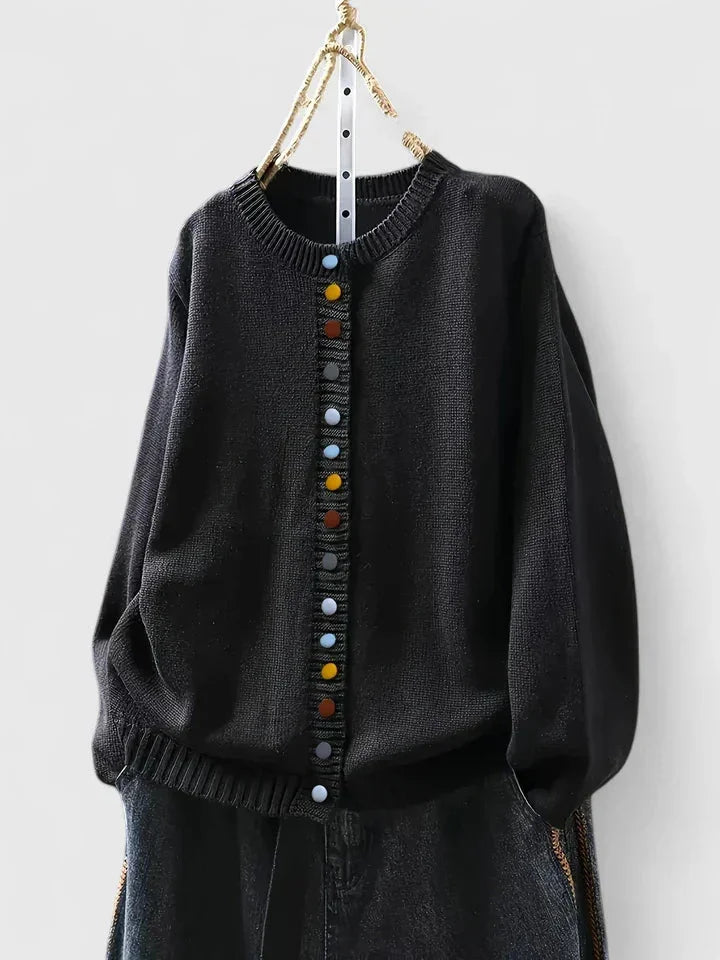 Close-up of a cozy knit women's relaxed fit cardigan sweater, featuring distinct multi-color buttons.