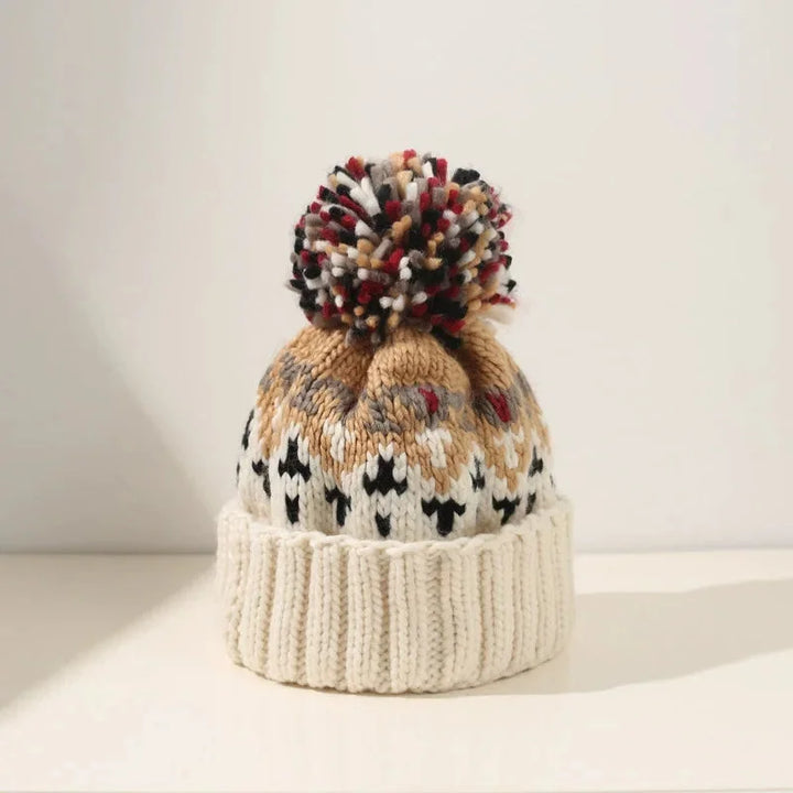 Stylish women's holiday beanie featuring a festive snowflake design, a fluffy pom-pom, and a warm ribbed cuff.