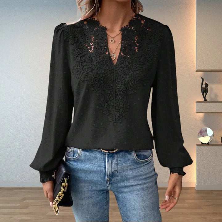 Close-up of a women's V-neck lace detail blouse, showcasing intricate lace and soft long smocked sleeves.