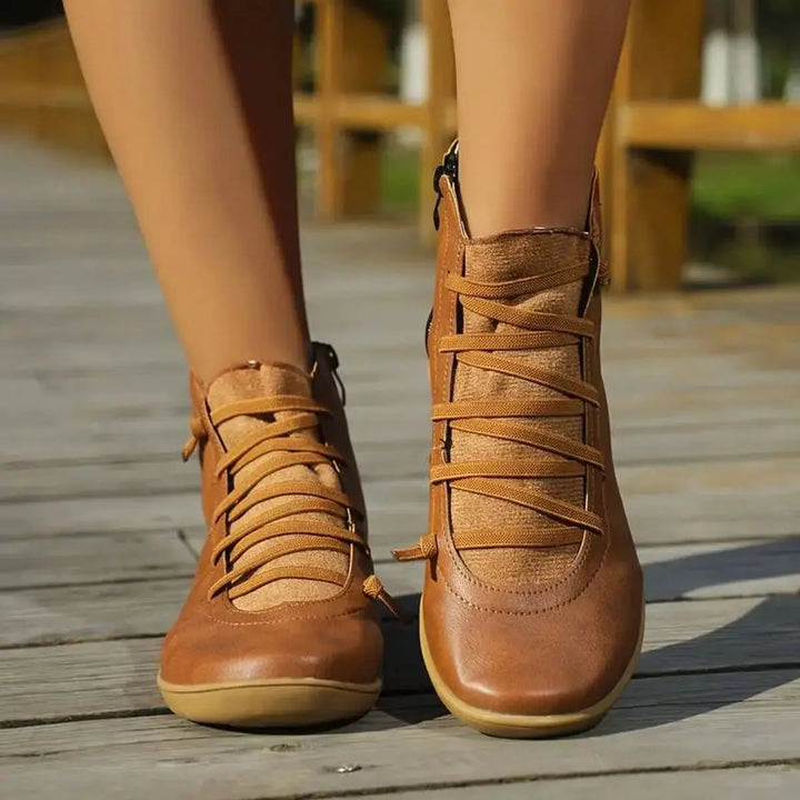 Comfortable flat women's ankle boots with secure lace-up front and convenient side zip for easy wear.