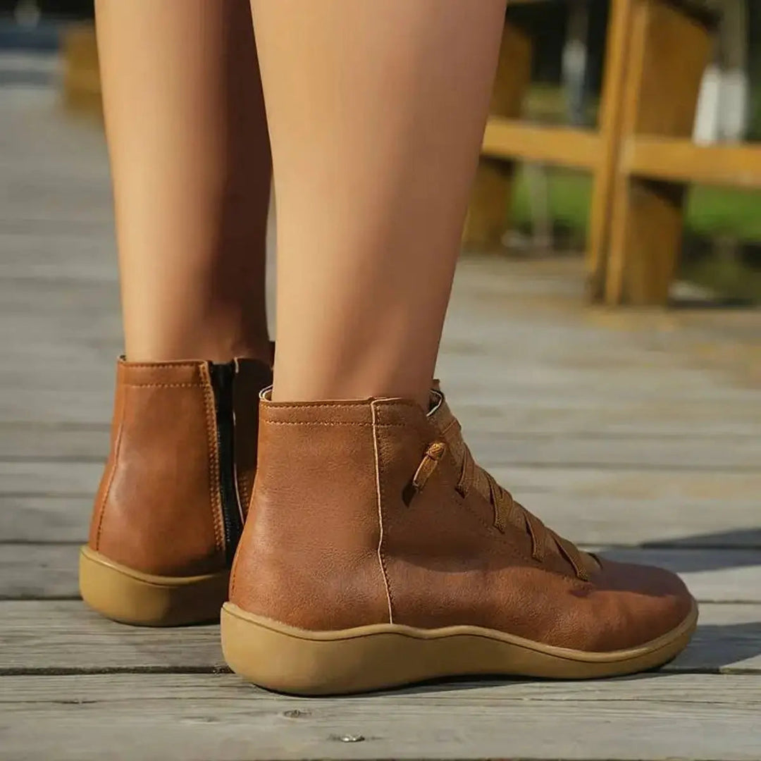 Woman wearing versatile lace-up flat ankle boots with side zip. Perfect for casual autumn & winter outfits.
