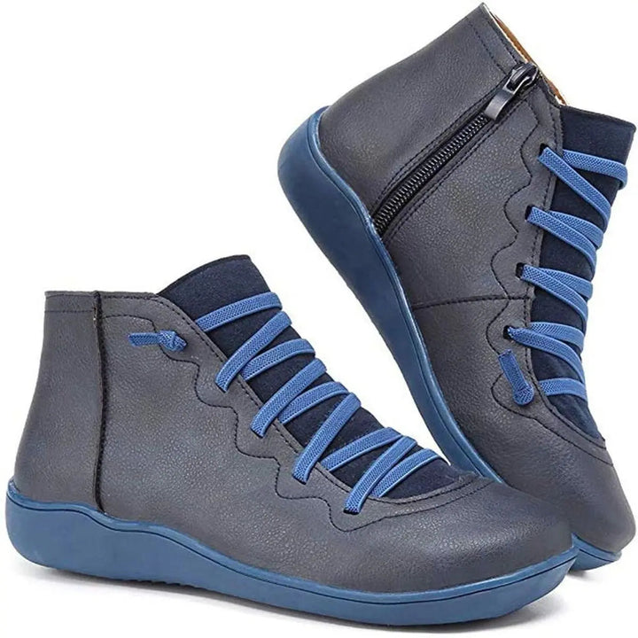 Close-up of women's lace-up flat ankle boots, highlighting the stylish front laces for secure fit.