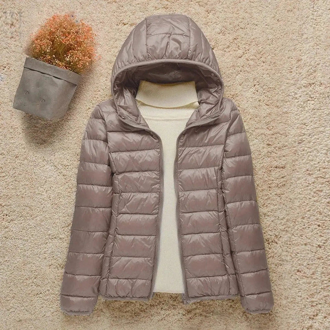 Women's lightweight hooded quilted puffer jacket, packable for travel and outdoor adventures.