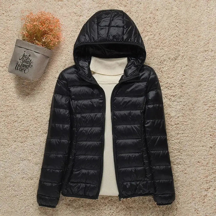 Elegant women's packable quilted puffer jacket with a hood, perfect for stylish autumn and winter outfits.
