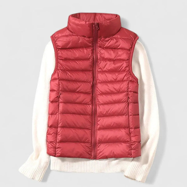 Smiling model wearing a fashionable women's lightweight puffer vest in a vibrant color, autumn outfit.