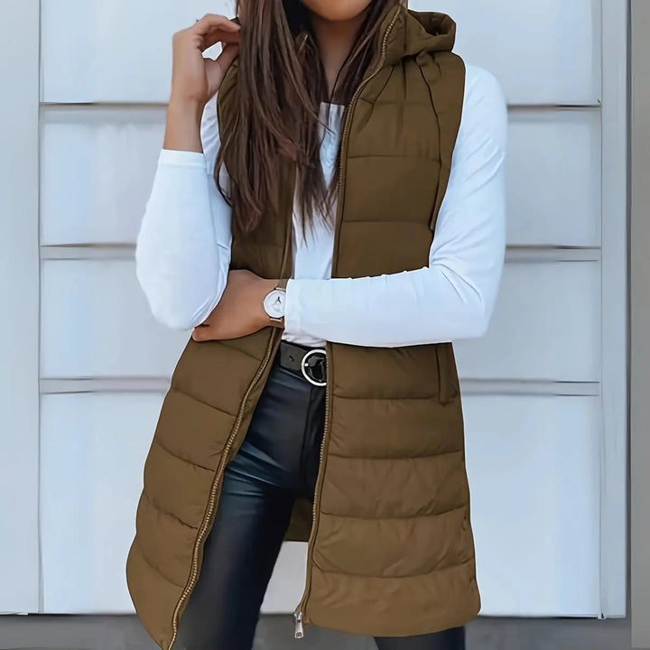 Hooded longline puffer vest for women, a lightweight sleeveless jacket ideal for versatile casual layering.
