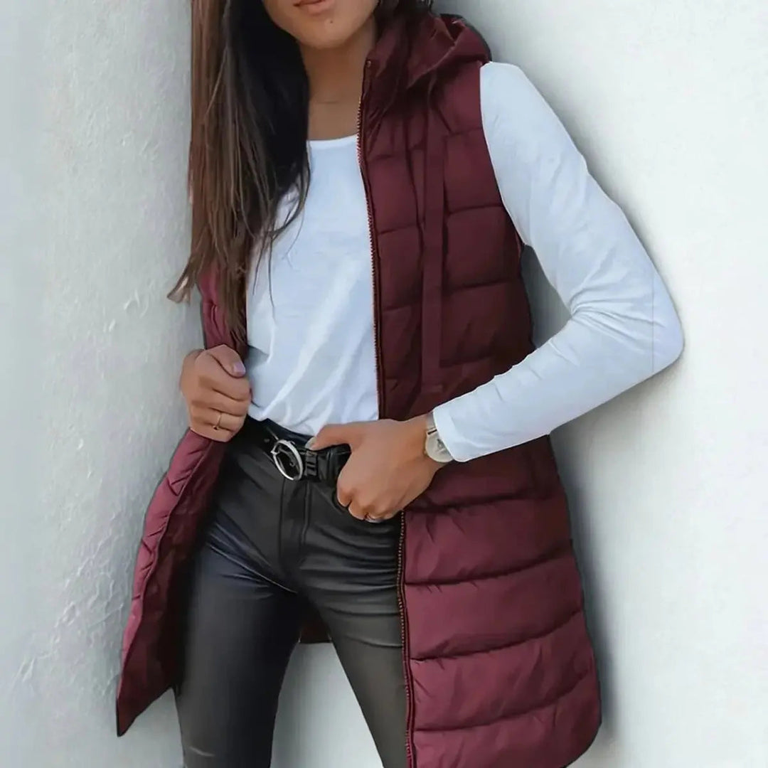 Elegant women's longline hooded puffer vest, a comfortable & warm layering piece for cold weather.