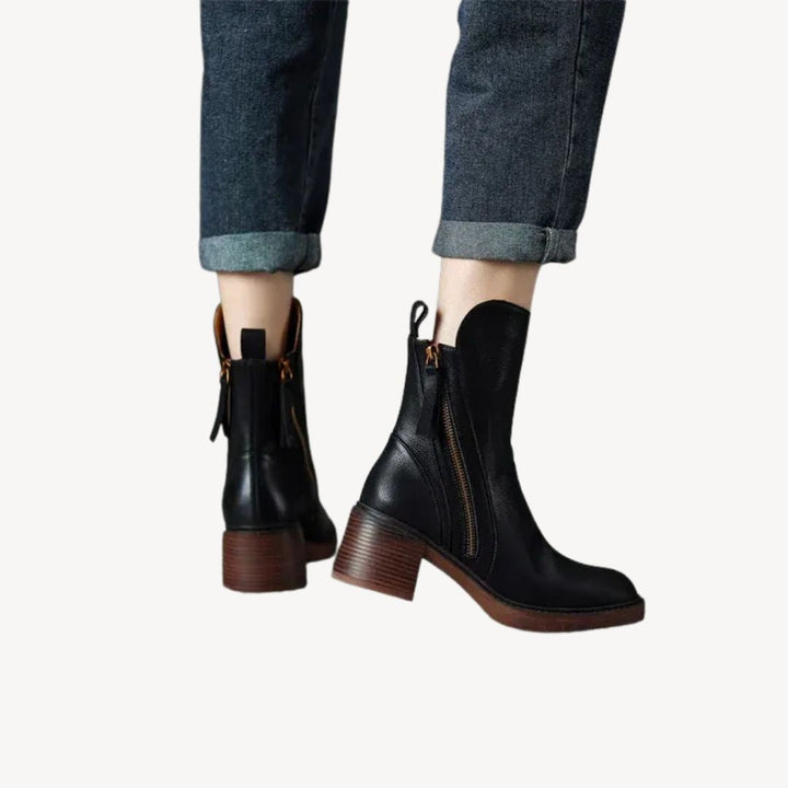 "Women's orthopedic black leather ankle boots with side zipper and moderate heel for comfort and style."