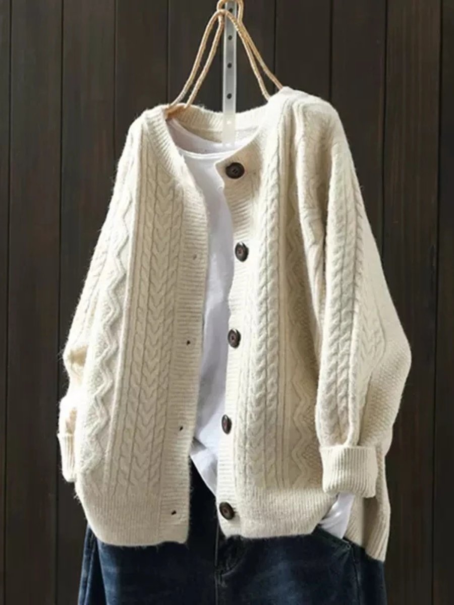 Close-up of a women's luxury cable-knit cardigan, showcasing intricate knit patterns and stylish button-down front.
