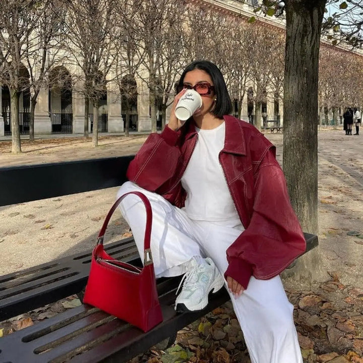 Stylish women's oversized bomber in wine red, quilted for warmth, with modern contrast stitch accents for fall.