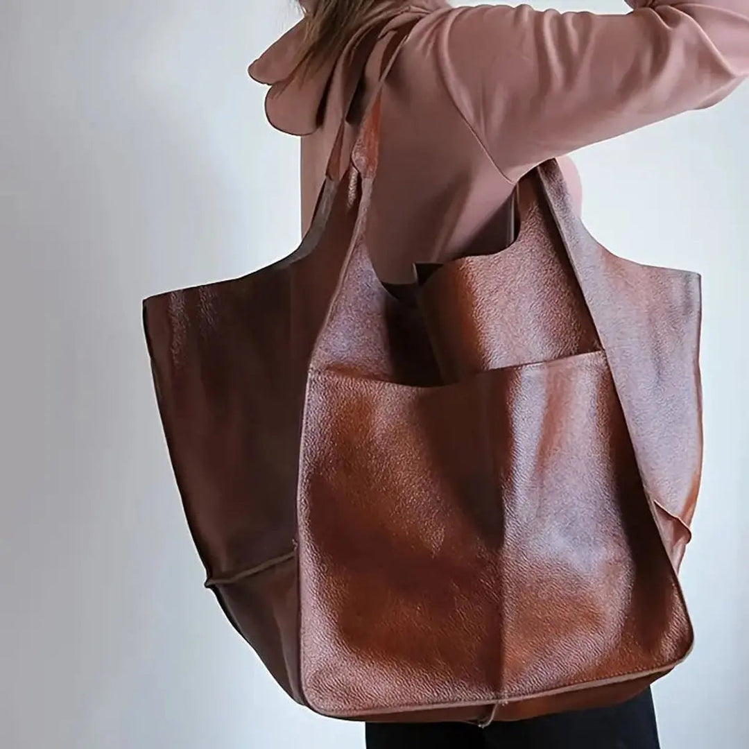 Close-up of magnetic closure on a women's oversized vegan leather tote.
