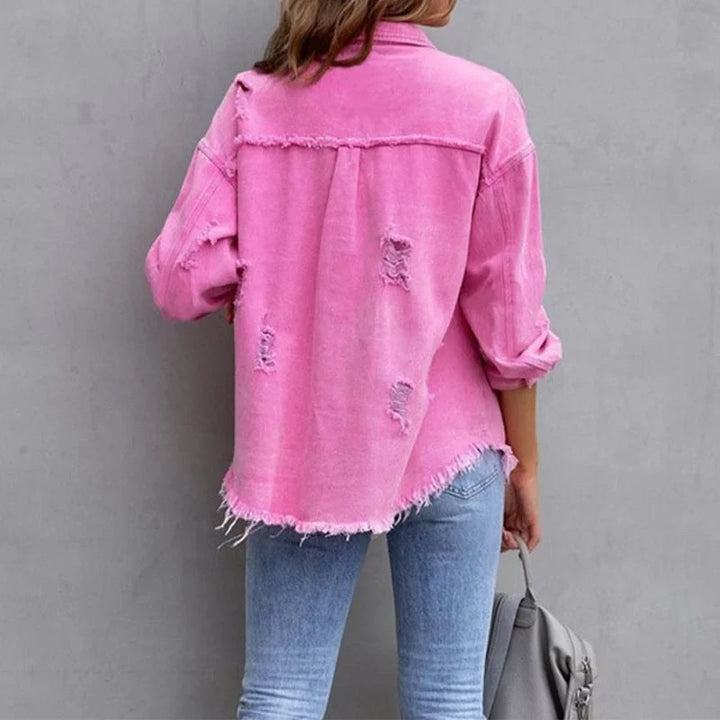 Stylish pink distressed women's denim jacket, featuring a frayed hem and classic button-front design.