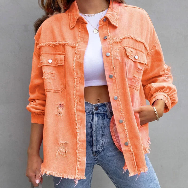 Pink distressed denim jacket for women, with frayed hem and button-front. Casual outerwear statement piece.