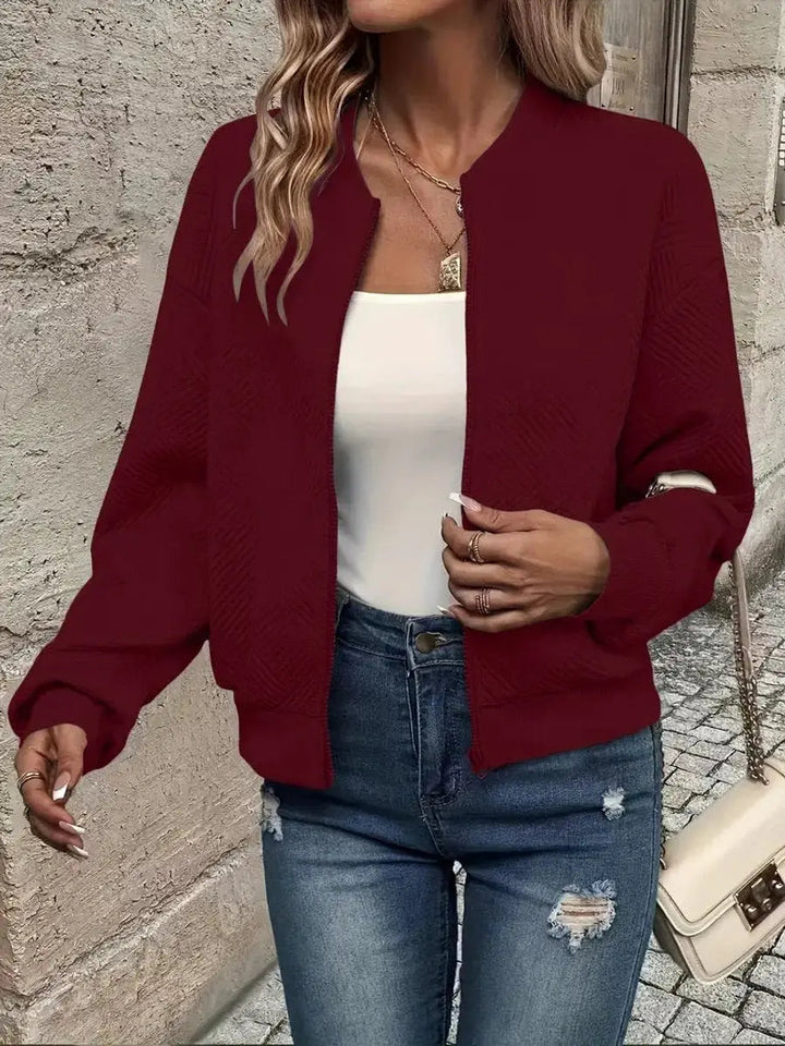 Lightweight women's cropped quilted bomber jacket, textured finish. A zip-up casual outerwear piece for autumn layering.
