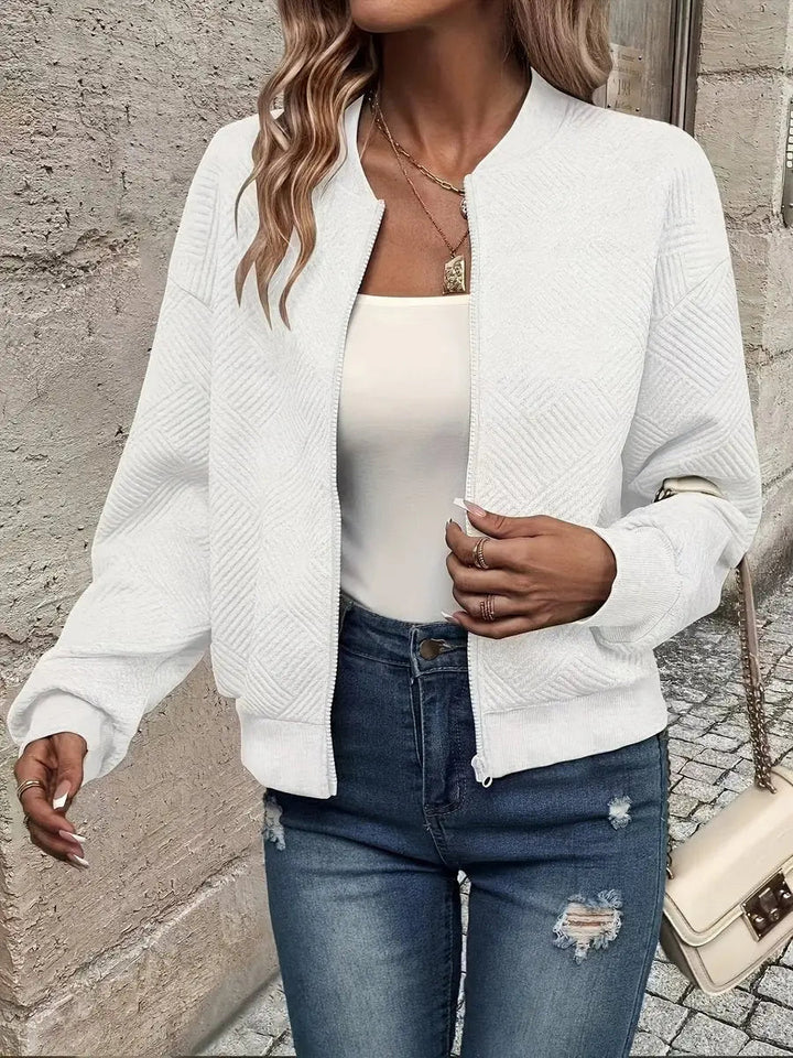 Cropped women's quilted jacket with zip-up bomber style. Textured fabric, ideal for autumn fashion & casual winter layering.