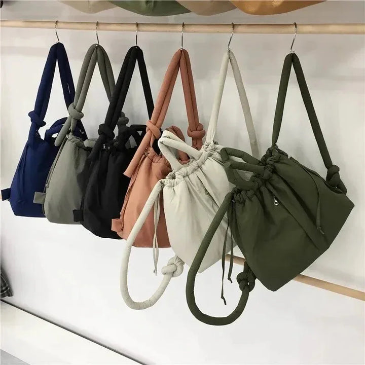 Modern women's puffer tote bag with a chic quilted finish and distinctive knot strap.