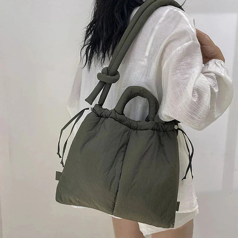 Women's quilted puffer tote bag with stylish knot strap, perfect for everyday carryall.