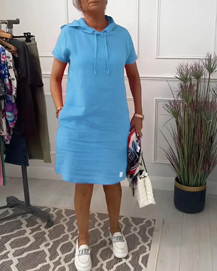 Front view of a women's short sleeve hoodie mini dress, showcasing pockets and a relaxed fit.