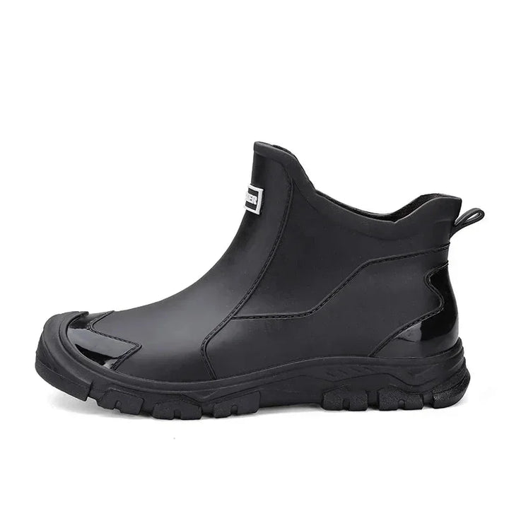 Black women's waterproof ankle rain boots with a durable, slip-resistant lug sole for extreme wet conditions.