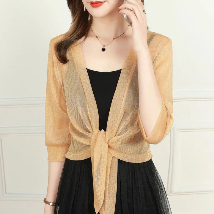 Resort wear women's sheer blouse with tie-front detail and practical 3/4 sleeves.