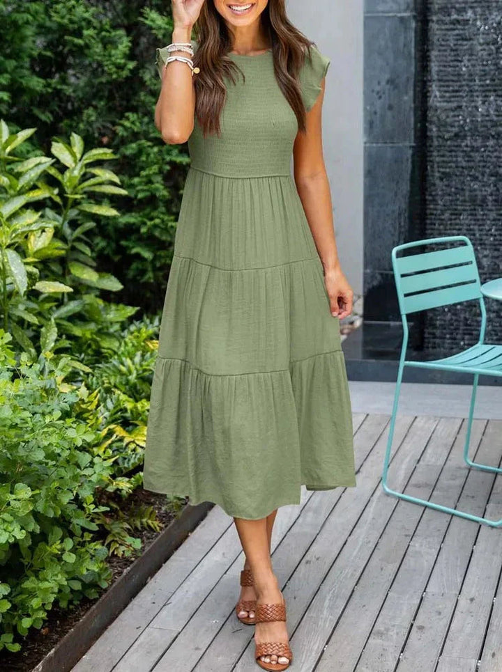 Women's sleeveless smocked midi dress with A-line skirt, airy fabric, perfect for summer occasions. Elegant and comfortable.