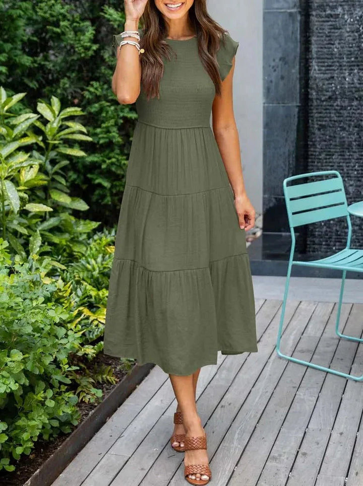 Women's sleeveless smocked midi dress with A-line skirt, airy fabric, perfect for summer occasions. Elegant and comfortable.