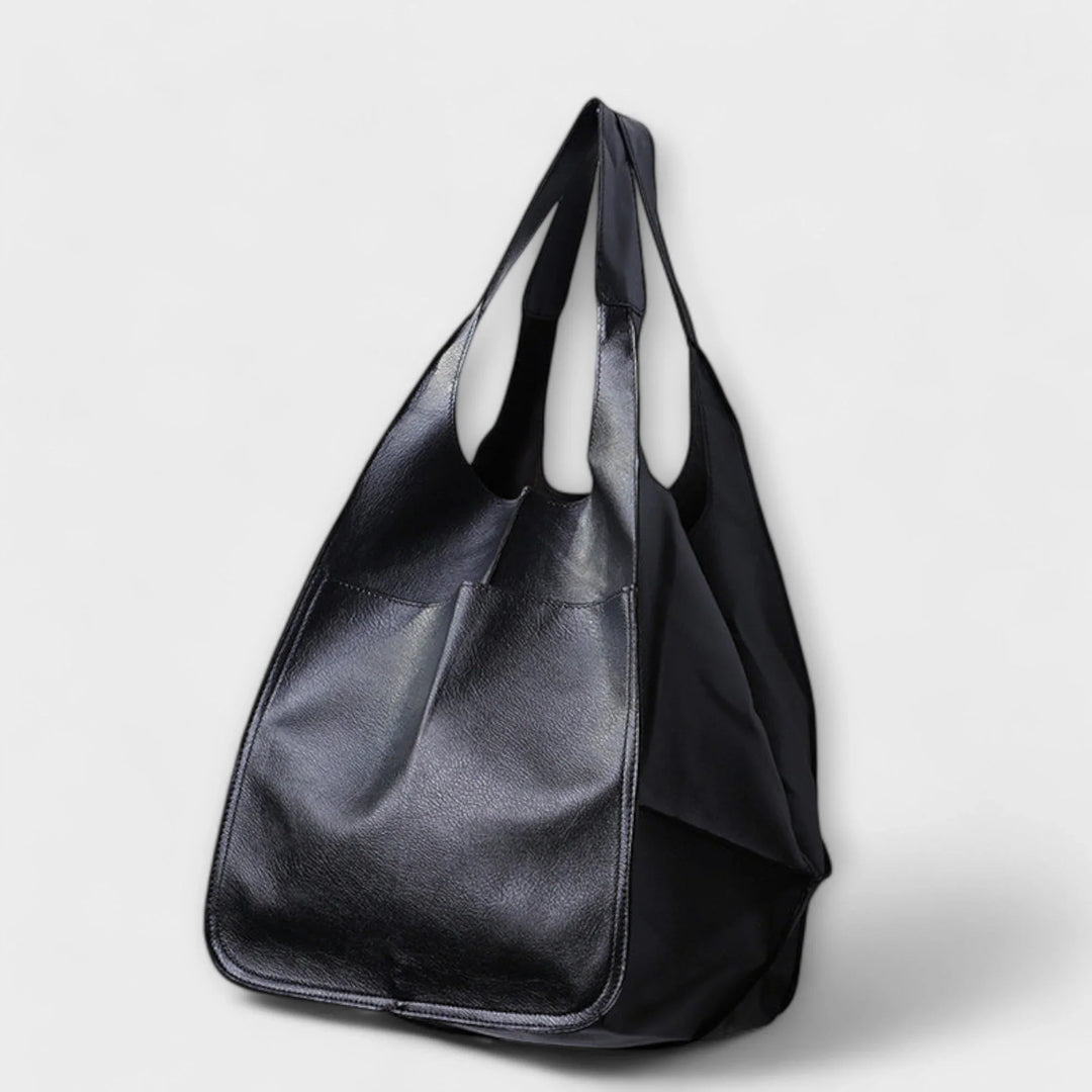 Women's spacious faux leather tote bag with functional exterior pockets, perfect for everyday carry.