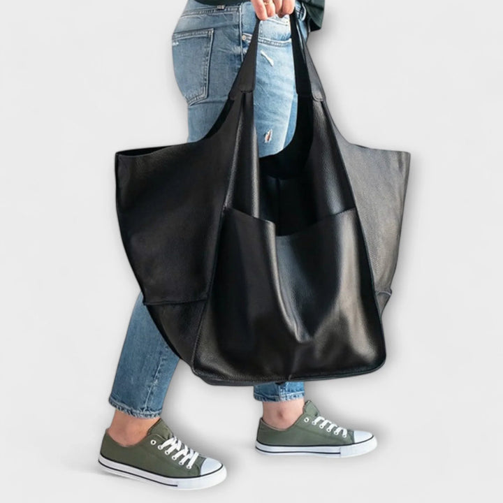 Chic women's faux leather handbag, a spacious shoulder tote with practical exterior pocket details.