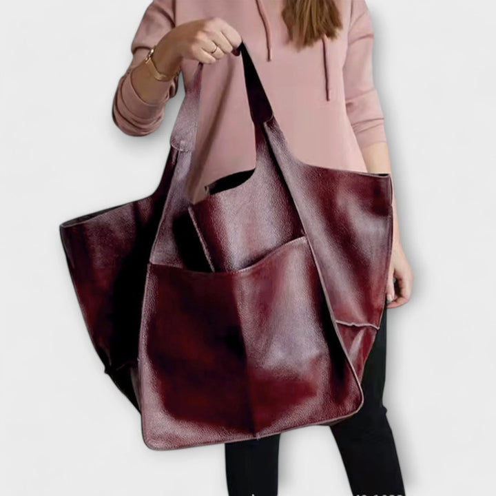 Elegant women's spacious faux leather tote bag, a versatile fashion accessory with outer pockets.