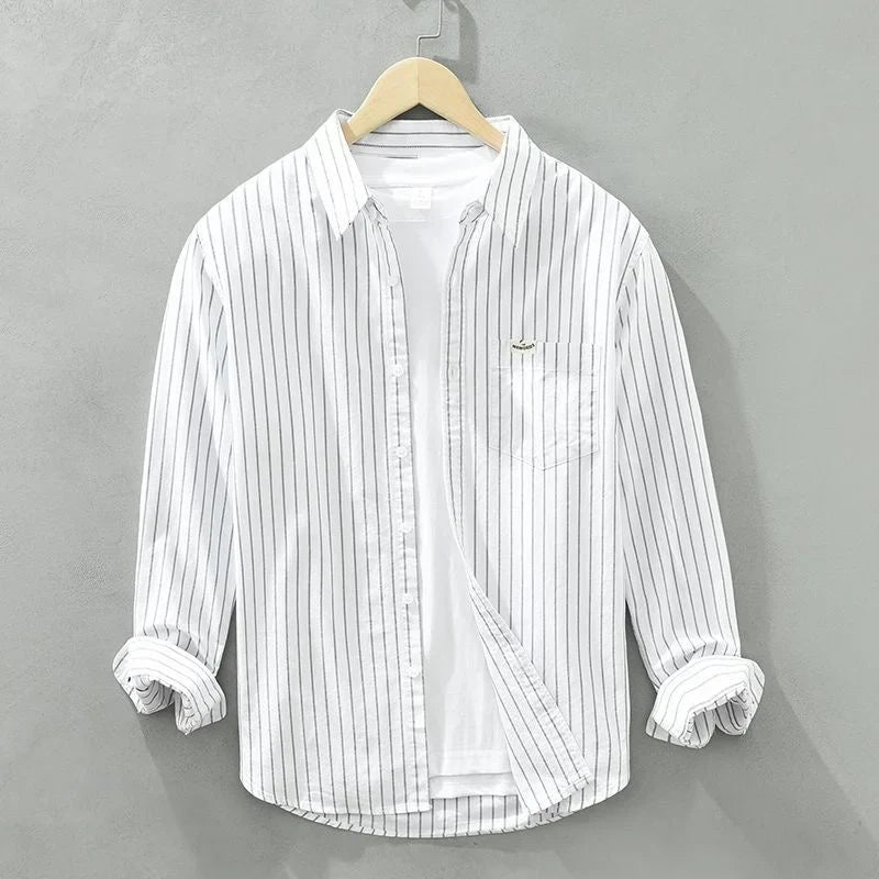 Versatile white striped long-sleeve women's button-up shirt with pocket, great for chic everyday & weekend style.