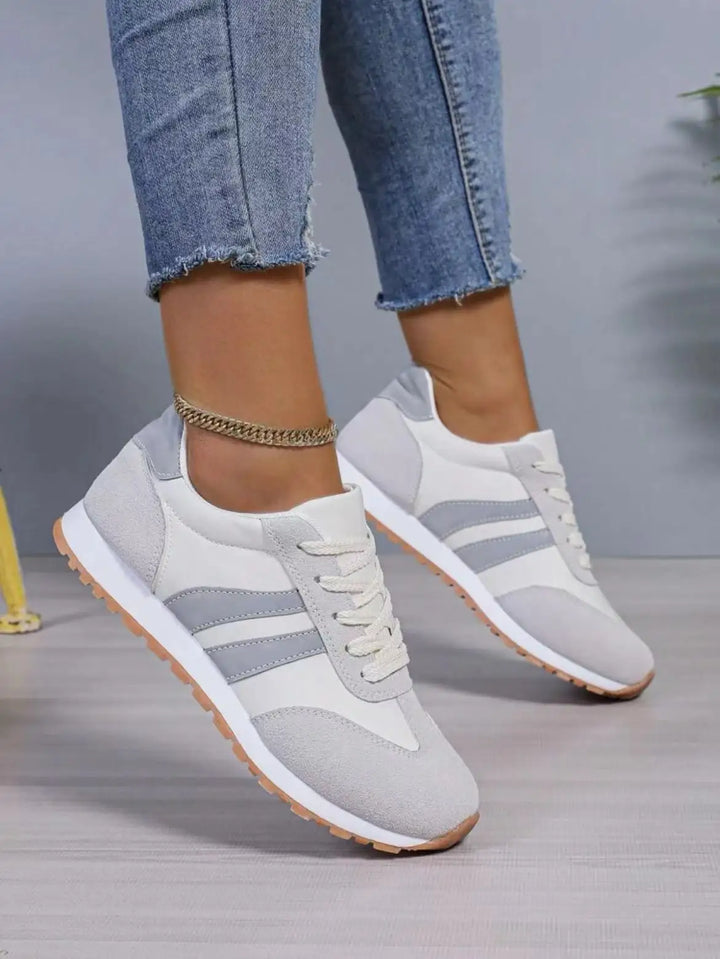 "Women's suede low top trainers with sleek suede upper, breathable fabric, and sporty side stripes for stylish comfort."