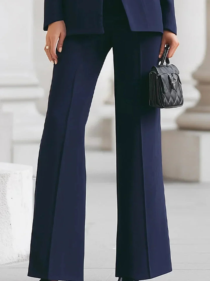 Stylish women's flared trousers paired with a tailored longline jacket, creating a sophisticated professional suit.