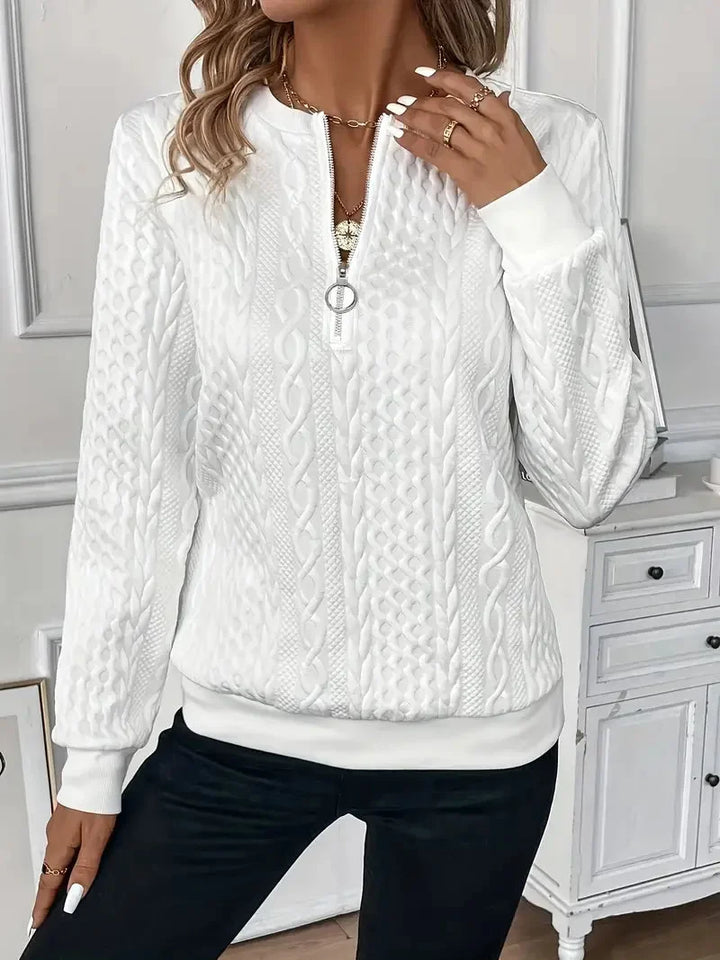 Close-up of women's textured knit quarter-zip sweater. Soft long sleeves for elegant winter wear.